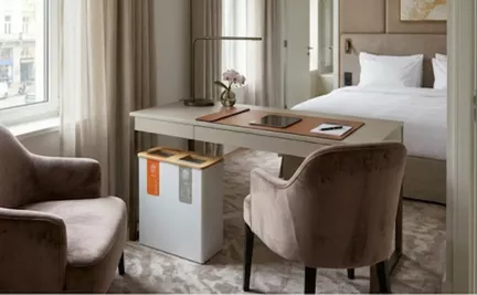Een closeup van een multi afvalcontainer onder een bureau in een hotelkamer