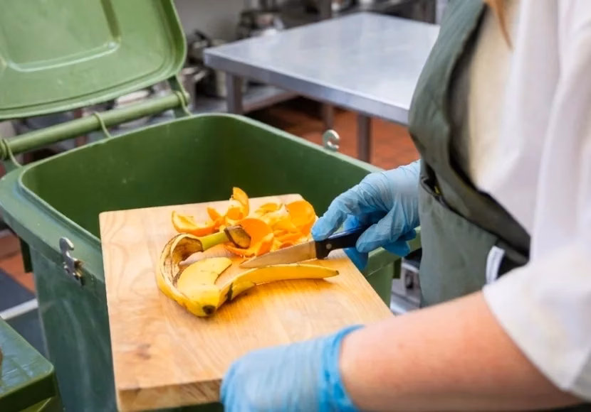 close up medewerker veegt fruitresten in swill container
