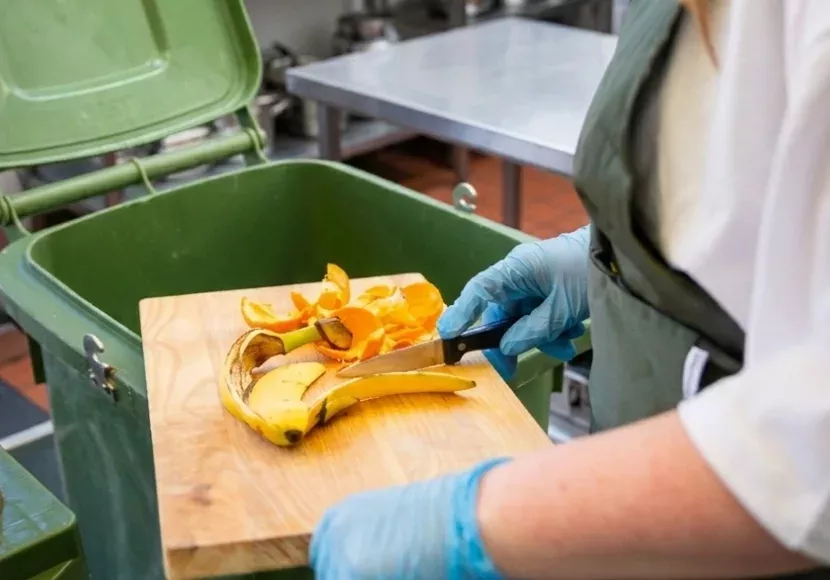 close up medewerker veegt fruitresten in swill container