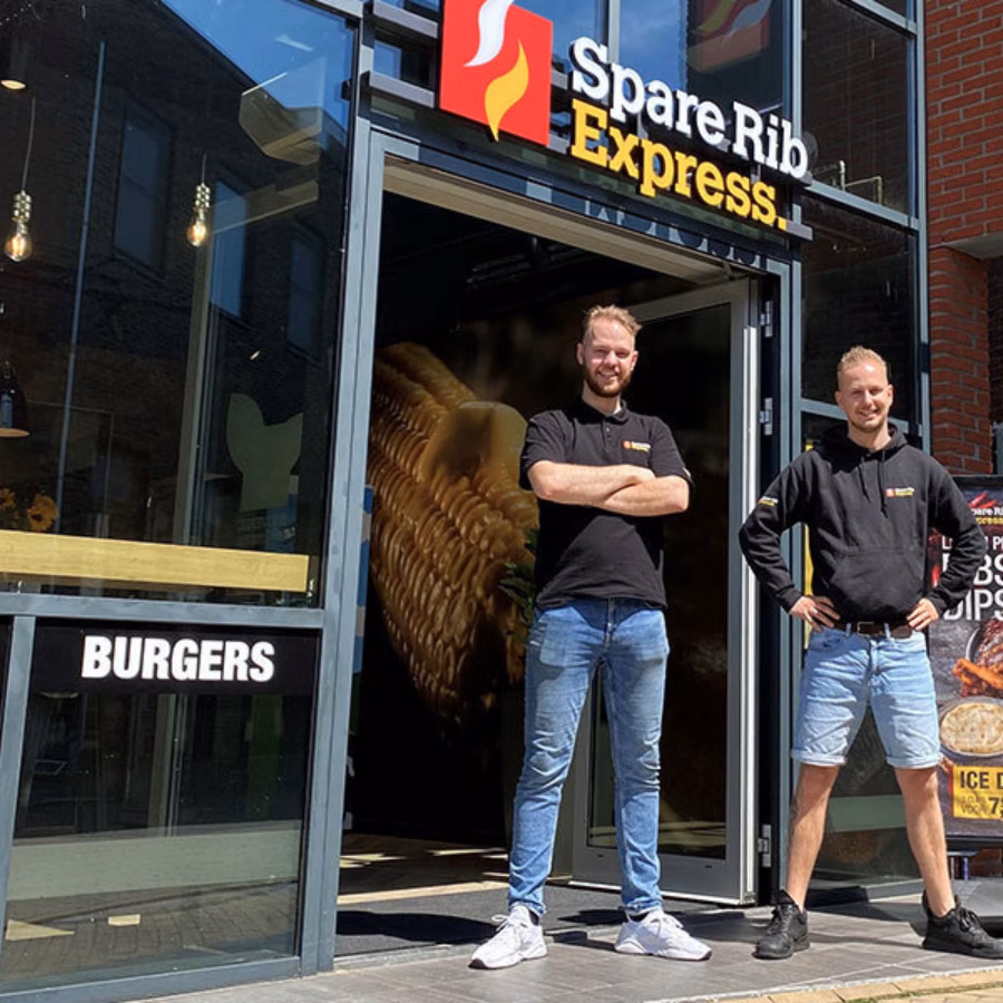 Twee jonge franchisenemers die voor een franchise locatie van SpareRib Express staan.