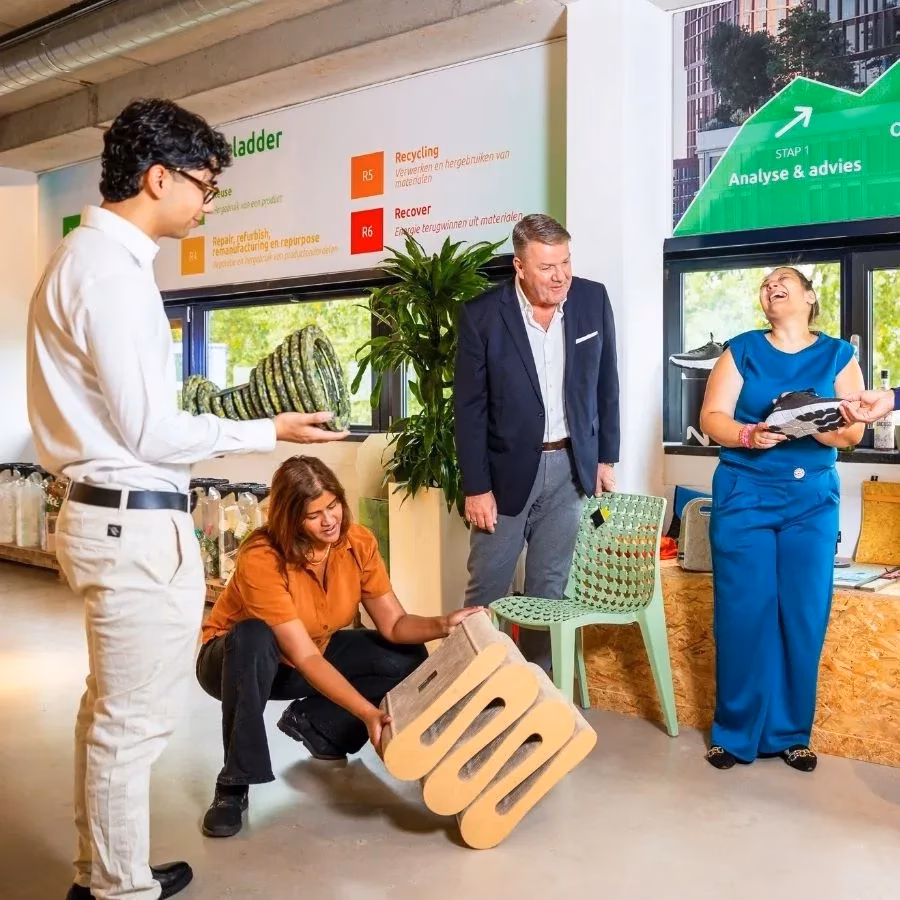 Duurzaamheid binnen Milieu Service Nederland - groep mensen in de Afval Experience met gerecylede producten in hun handen
