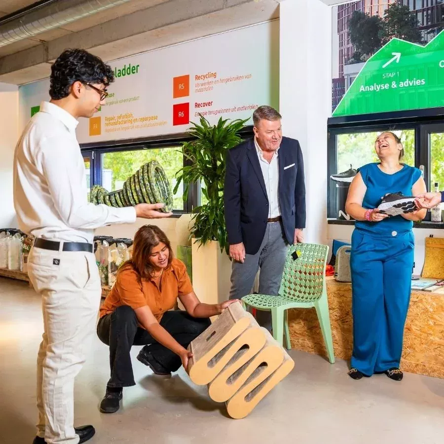 Duurzaamheid binnen Milieu Service Nederland - groep mensen in de Afval Experience met gerecylede producten in hun handen