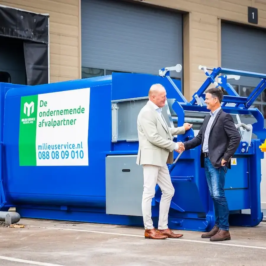 Perscontainers met collega's ervoor in gesprek
