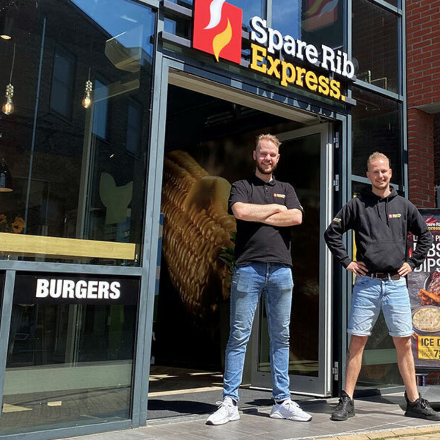 Twee jonge franchisenemers die voor een franchise locatie van SpareRib Express staan.
